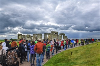 Tourists visit Stonehenge under cloudy skies