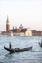 Gondolier rowing in Venetian gondola on the sea