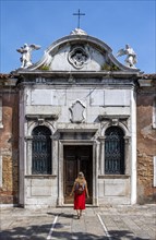 Tourist in red dress in front of a house