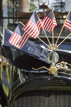 American flags on hood ornament of classic vintage car