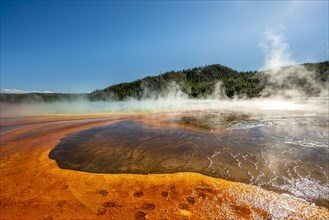 Steaming hot spring with colored mineral deposits