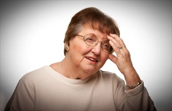 Senior woman with aching head with a dramatic vignetted background