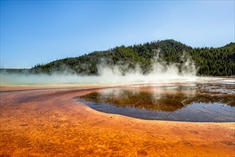 Steaming hot spring with colored mineral deposits