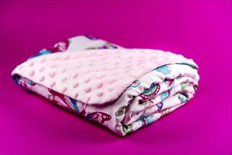 Sweet and cute pink baby blanket with butterfly pattern isolated on pink background