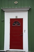 Traditional red wooden door with ornaments decorations in red wooden house Swedish house in Vimmerby