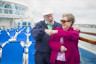 Happy senior couple fist bump on the deck of a luxury passenger cruise ship