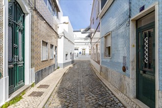 Narrow street with traditional fishermen's houses in Olhao