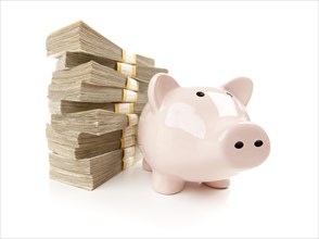 Pink piggy bank with stacks of hundreds of dollars isolated on a white background