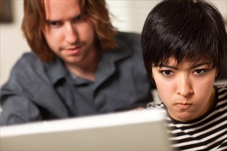 Young man and diligent woman using laptop computer together