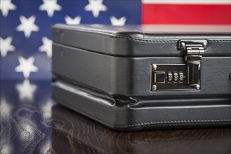 Black leather briefcase resting on table with american flag behind