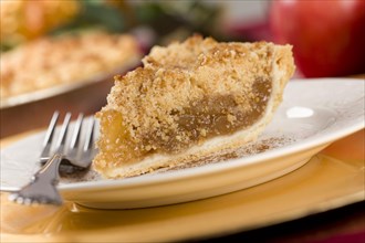 Apple pie slice with crumb topping and fork