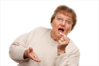 Attractive senior woman taking pills isolated on a white background