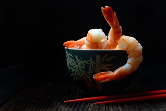Cooked prawns in shell with chopsticks