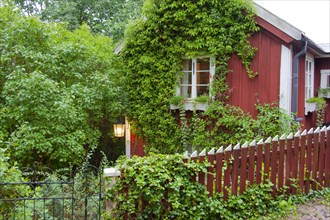 Red beranken Swedish house with picket fence wooden house in Vimmerby
