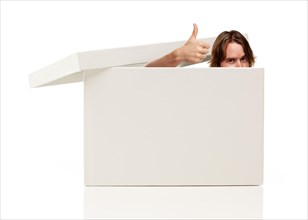 Young man with thumbs up and popping his head out from a blank white box isolated on a white background