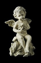 Cherub with dramatic side lighting on a black background