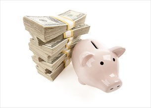 Pink piggy bank with stacks of hundreds of dollars isolated on a white background