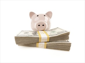 Pink piggy bank with stacks of hundreds of dollars isolated on a white background