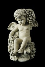 Cherub with dramatic side lighting on a black background