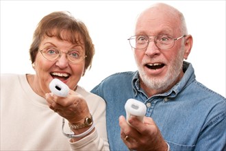 Happy senior couple play video game with remote controls on a white background