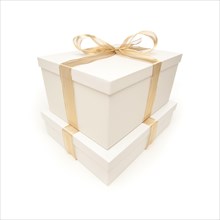 Stacked white gift boxes with gold ribbon and bow isolated on a white background