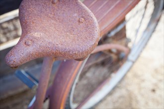 Abstract of old rusty antique bicycle seat in a rustic outdoor setting