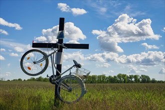 Cross with bicycle at country road near Trebbin