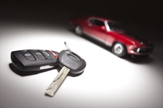 Car keys and sports car under spot light