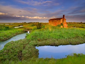 Abandoned stone house in the evening light in the lagoon of Venice