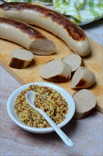 Bowl of Dijon mustard and sausages