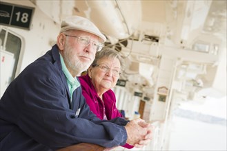 Happy senior couple enjoying the view from deck of a luxury passenger cruise ship