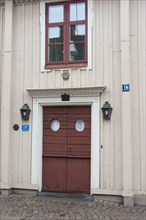 Traditional facade with red wooden door with ornaments decorations in red wooden house Swedish house in Vimmerby