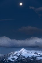 Full moon over summit of Oetztaler Wildspitze