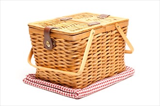 Picnic basket and folded blanket isolated on a white background