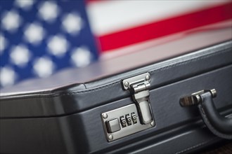 Black leather briefcase resting on table with american flag behind