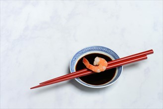 Cooked shrimp on chopsticks and shell with soy sauce