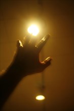 Hand reaching towards a light