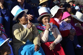 Two indigenous woman lapping up ice cream at the parade on the eve of Inti Raymi