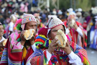 Indigenous man blows conch shell during parade on eve of Inti Raymi