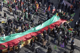 Protesters carry outstretched flag of the autonomous region of Kurdistan