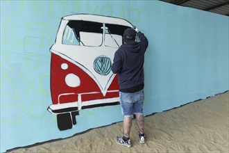 Graffitimaler sprays VW bus