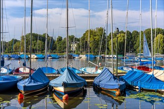 Sailing boats covered with blue rain tarpaulin on the Aussenalster in Hamburg