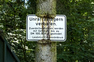 Sign Unrat ablagern verboten at the tree trunk