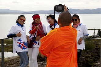 Asian tourists with Buddhist monk