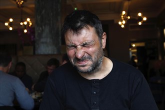 Man in Apotek restaurant drinking Brennivin and shaking himself