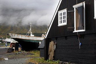 Black wooden house and fishing boat