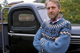 Man in Icelandic sweater in front of oldtimer