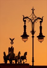 Quadriga on the Brandenburg Gate with old Berlin gas lantern in the sunset