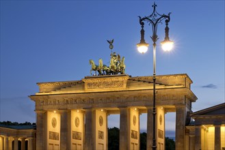 Quadriga on the Brandenburg Gate with old Berlin gas lantern in the evening
