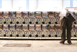 Man using Gashapon capsule toy vending machines in Akihabara